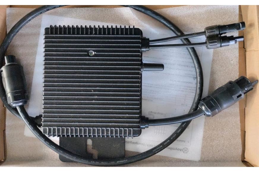 Die Anschlüsse des Hoymiles HM-350 Balkonkraftwerk Mikrowechselrichters sind in der Nahaufnahme zu sehen und der Mikrowechselrichter liegt in der Originalverpackung.